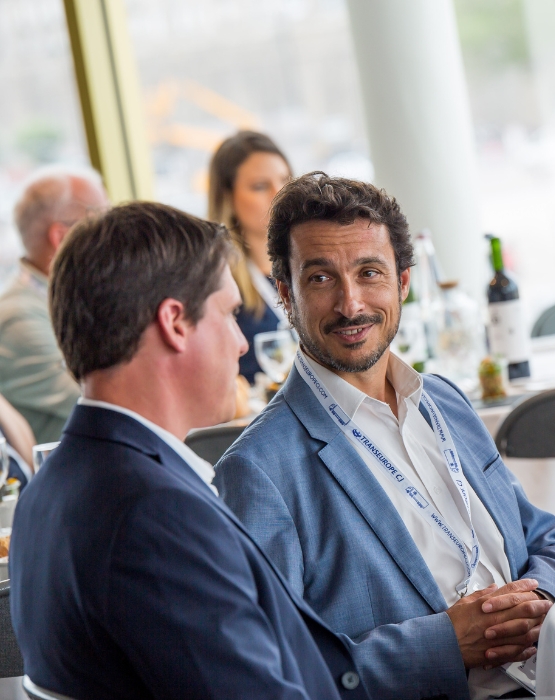 Personnes souriantes qui discutent à table lors d'un déjeuner 