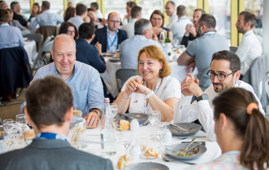 Groupe de personnes souriantes qui déjeunent 