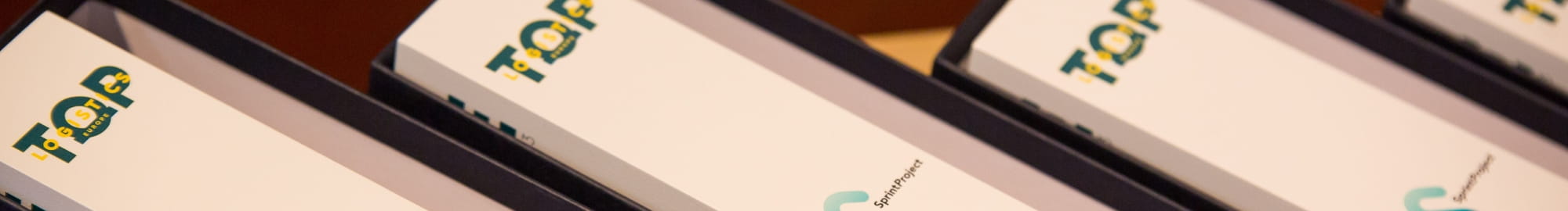 Plusieurs trophées de prix RSE posés sur une table avec un micro 
