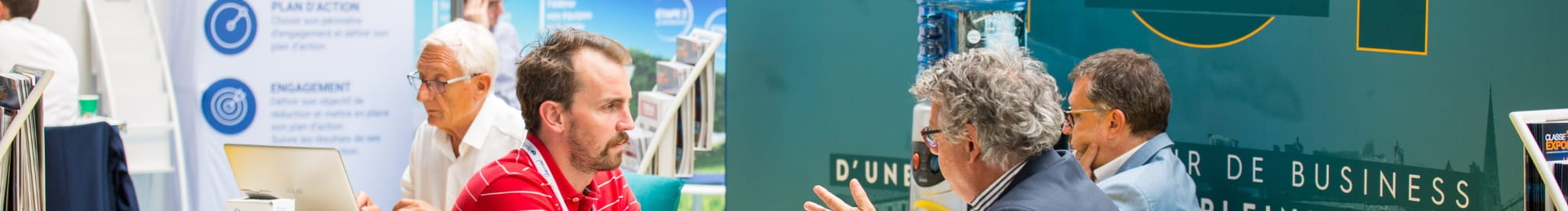  personnes qui discutent sérieusement à l'espace presse devant une bâche top logistics europe, au milieu des stands