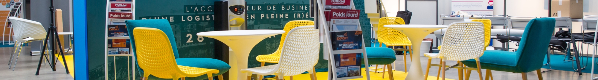 un espace presse avec des tables, des chaises confortables et des magazines sur la logistique, la supplychain et le transport.