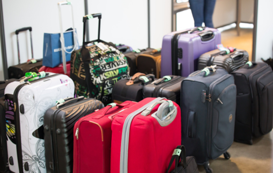 De nombreuses valises rassemblées et gardées en sécurité dans le vestiaire de l'évènement, avec une hôtesse dédiée.
