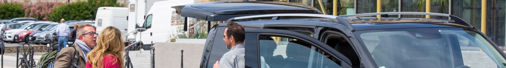 Groupe de personnes discutant avec chauffeur de van à côté de son véhicule devant top logistics europe.
